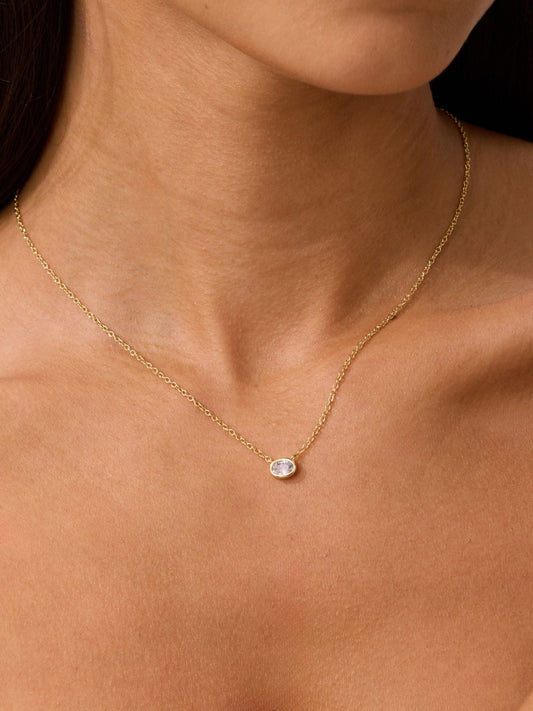 Gold oval diamond necklace with small oval pendant near collar