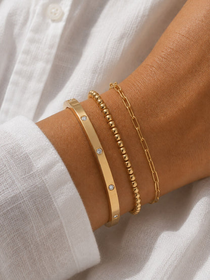 Gold paperclip chain bracelet on wrist, with adjustable clasp and extender