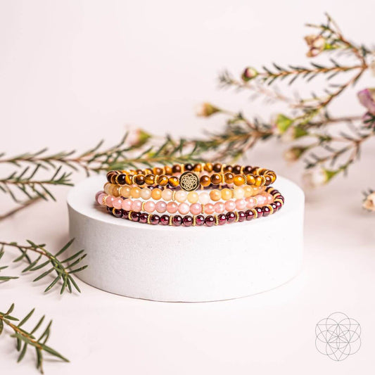 Beaded bracelet set of 4 with gold-tone beads, pink stones, and round charm