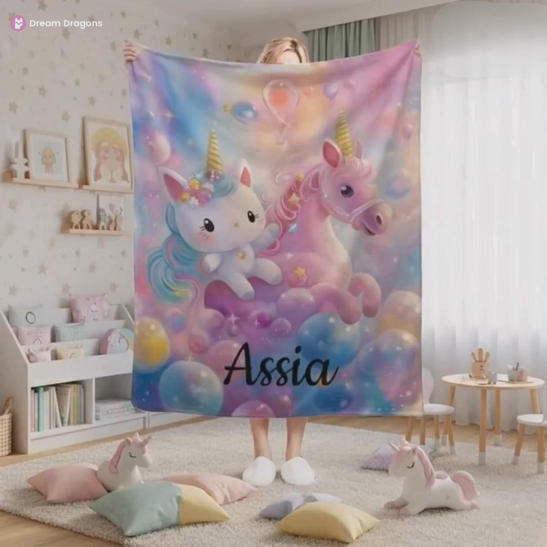 Smiling woman holding the purple, pink name blanket with a unicorn and a Hello Kitty and the name Assia on it.