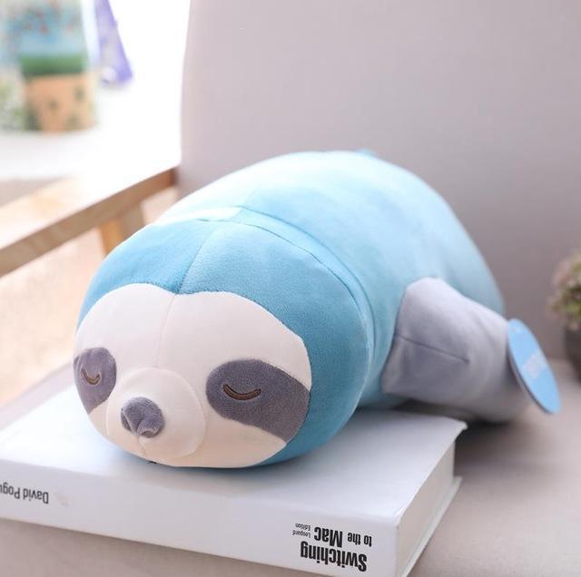 Blue and grey sleeping sloth plush close-up with closed-eye face and tail