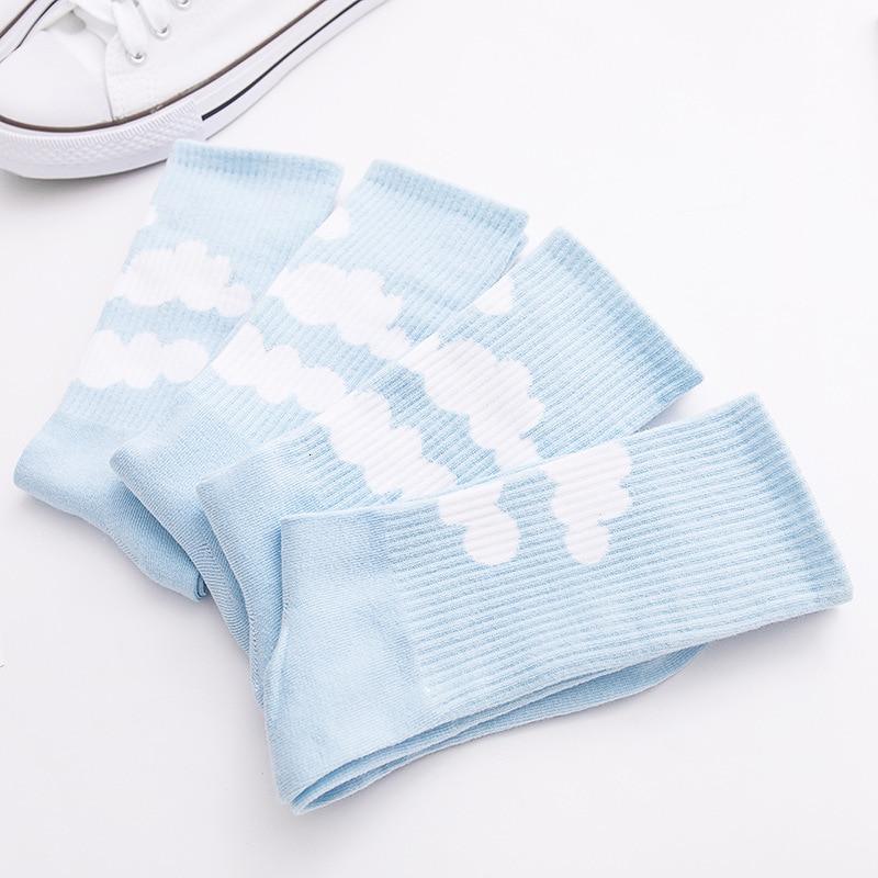 Light blue crew socks stacked together, white cloud pattern on the legs.