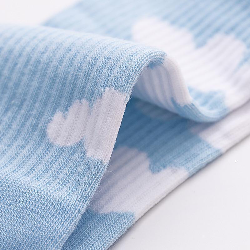 Light blue sock with white cloud motif, close-up of ribbed fabric.