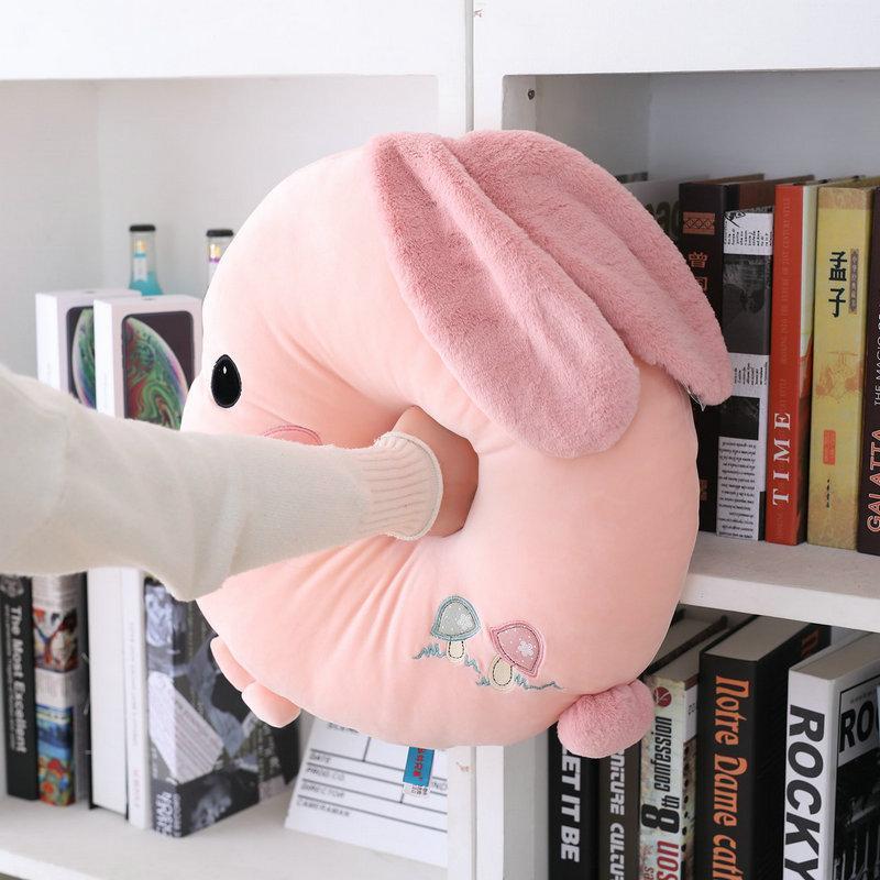 Pink round plush rabbit pillow with long velour ears and embroidered belly.