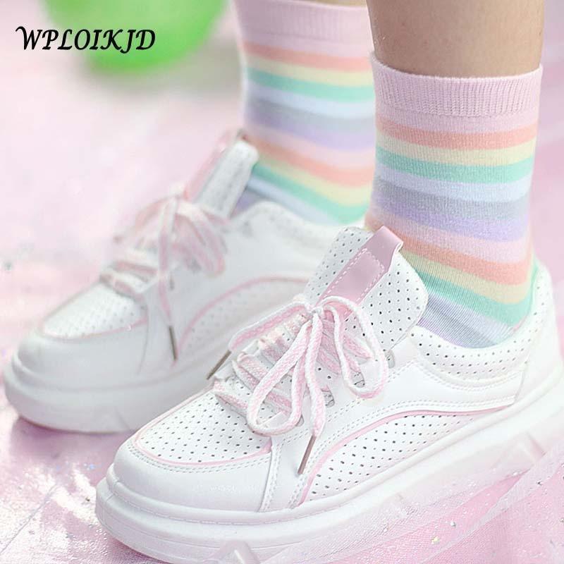 Pastel rainbow socks with pastel striped bands and ribbed cuffs, worn with white sneakers