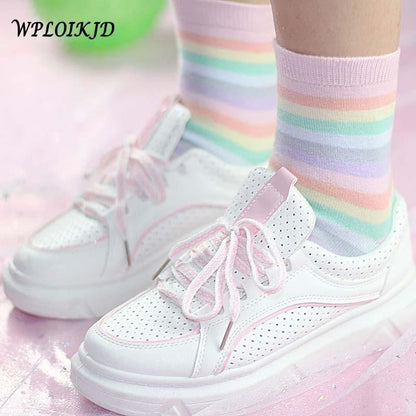 Pastel rainbow socks with pastel striped bands and ribbed cuffs, worn with white sneakers
