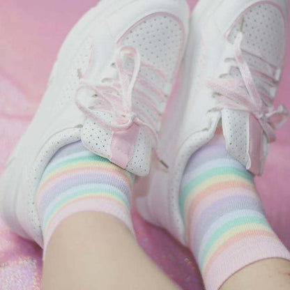 Pastel rainbow striped socks with ribbed cuffs, peeking from white sneakers
