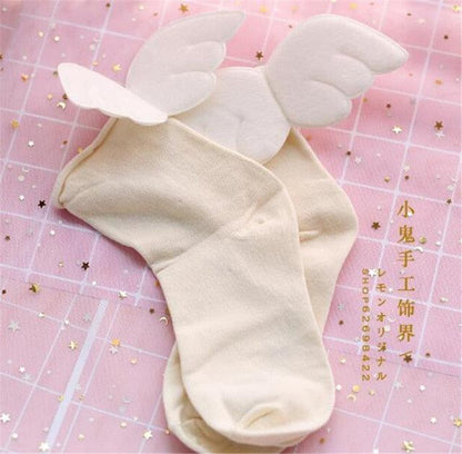 Angel wing socks with white cloud wings, beige knit crew socks.