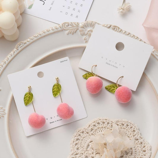 Drop earrings with pink pom-pom balls and green leaf charms on gold ear wires