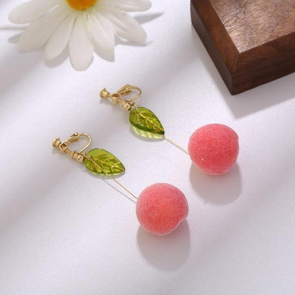 Dangle earrings with pink pom-pom spheres and green leaf charms on gold hooks