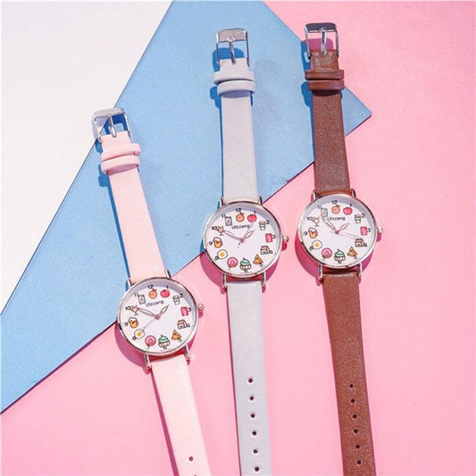 Set of three round watches with food-themed dials on white, light pink, and brown straps