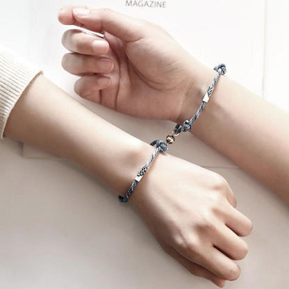 Magnetic attraction bracelet set on wrist, blue patterned braided cords with silver tube ends