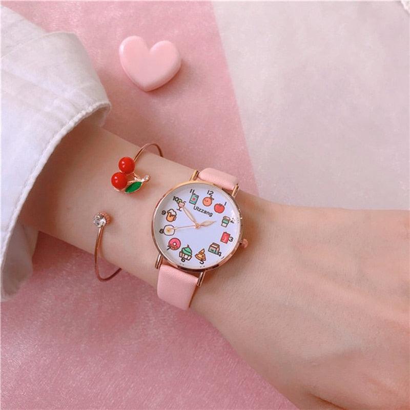 Pink wristwatch with food-themed dial and pink strap, paired with cherry charm bracelet