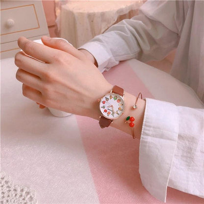 Kids watch set with brown leather strap, food-themed dial, and red cherry charm bracelet