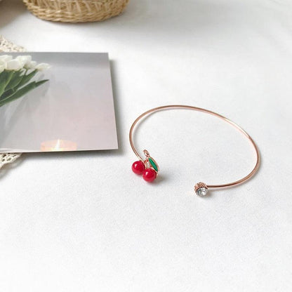Cherry charm bangle bracelet with red bead pair and green leaf detail