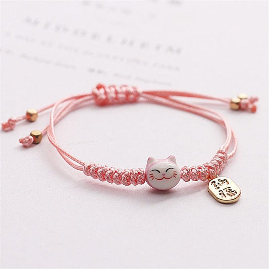 Pink macrame cat charm bracelet with gold-tone tag and small dangling beads
