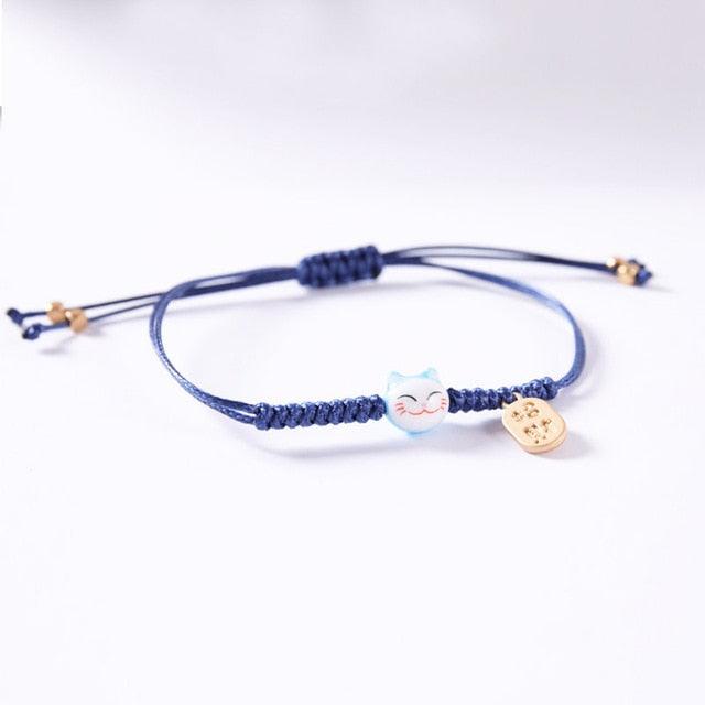 Blue cord cat charm bracelet with light blue cat bead and gold-tone heart tag