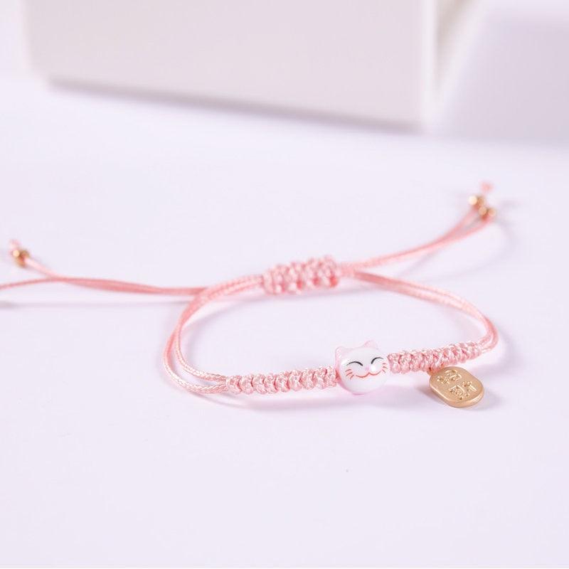 Light pink macrame cat charm bracelet with light pink cat bead and gold-tone tag