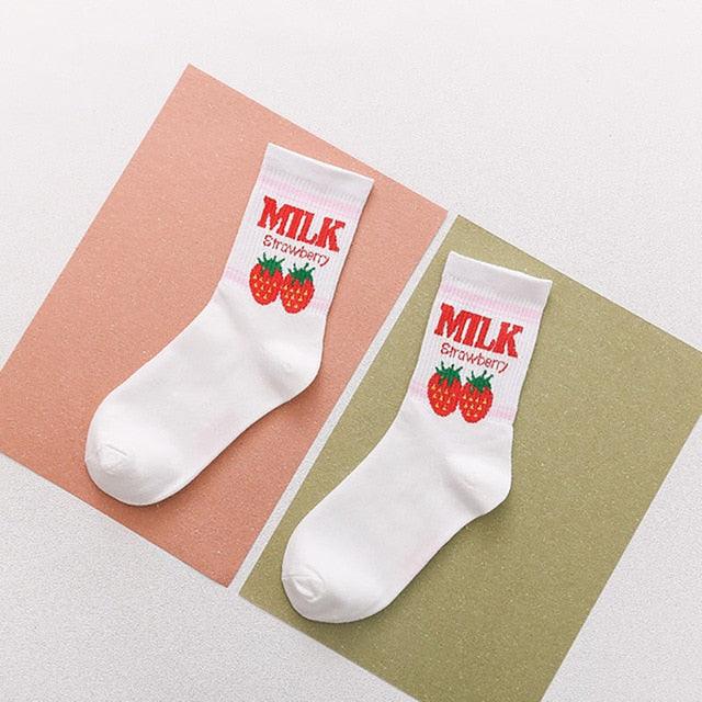 Pairs of white socks with red strawberry “MILK” text cuffs