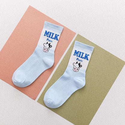 White socks with blue “MILK” text and cow face graphic on blue-tinted cuffs