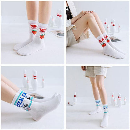 White crew socks with “MILK” strawberry and cow graphics worn on model legs