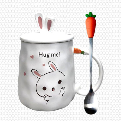 White ceramic bunny mug with 'Hug me!' rabbit and hearts, plus carrot-handled spoon.