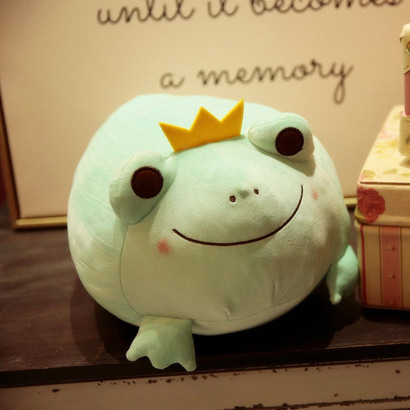 Green frog plush with yellow crown, smiling stitched face, and small embroidered details