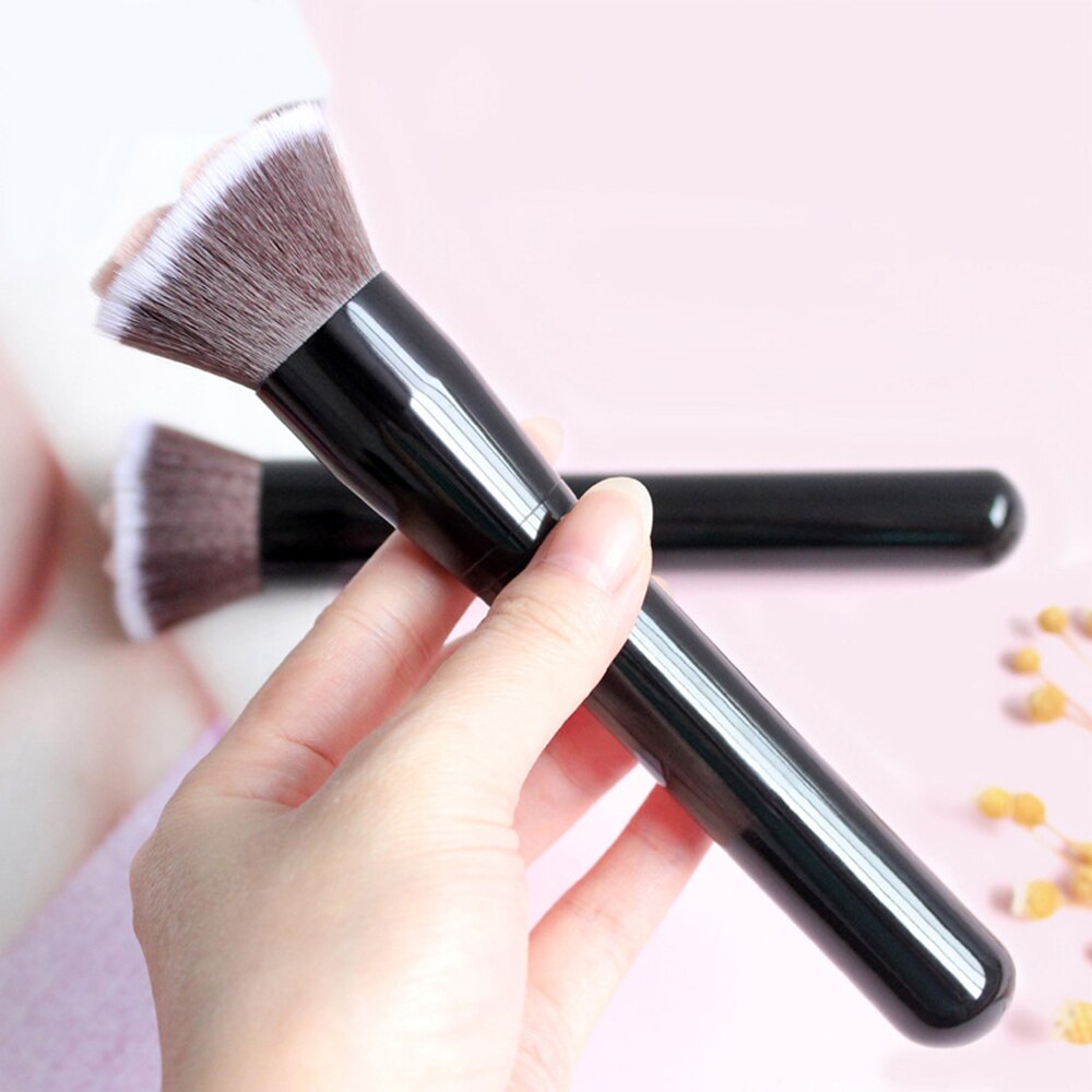 Cat paw makeup brush with black handle and soft brown bristles, angled view