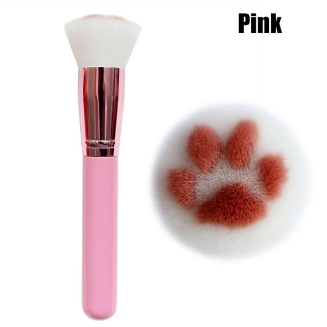 Cat paw makeup brush with pink handle and white bristles marked with orange paw pads