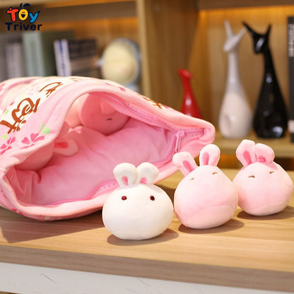 Pink bunny pillow plush pouch with three bunny plush toys on a wooden surface