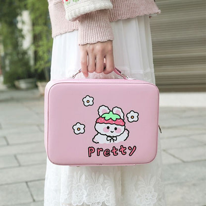 Pink kawaii animal makeup storage case with lid and handle, held by a person outdoors.