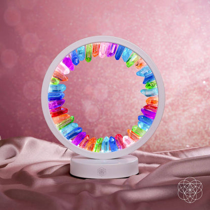 Rainbow crystal aura lamp with glowing multicolor ring on draped fabric