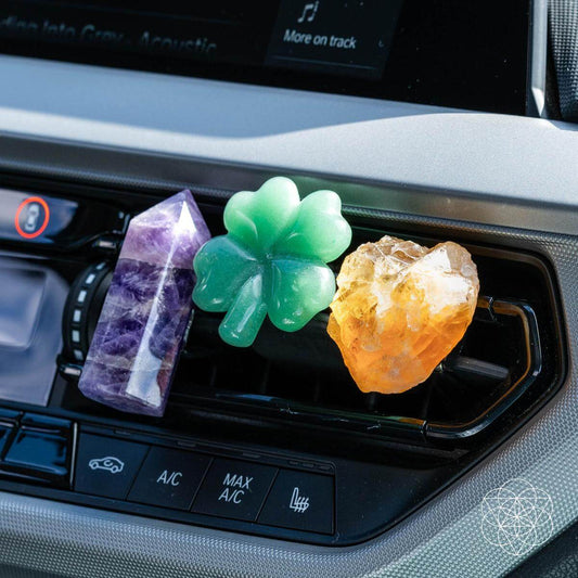 Set of three crystal car fresheners with purple, green clover, and orange pieces on vent