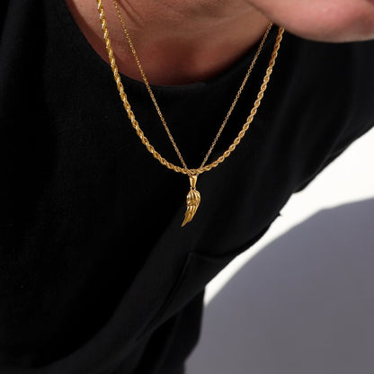 Close-up of gold angel wing pendant on twist rope chain
