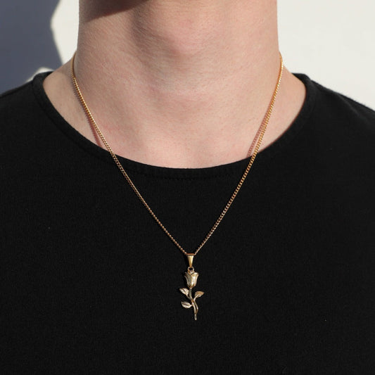 Gold rose pendant necklace on model with small leaf-branch drop pendant