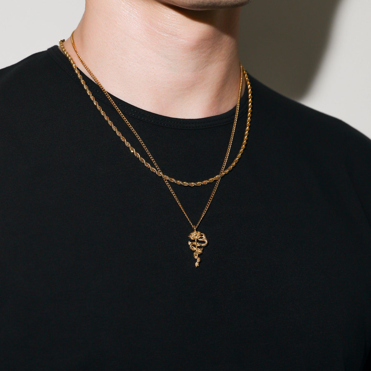 Gold serpent rose pendant necklace with coiled rose pendant and layered chain length
