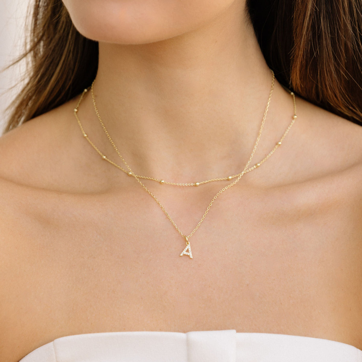 Gold satellite chain necklace with small bead stations and letter A charm
