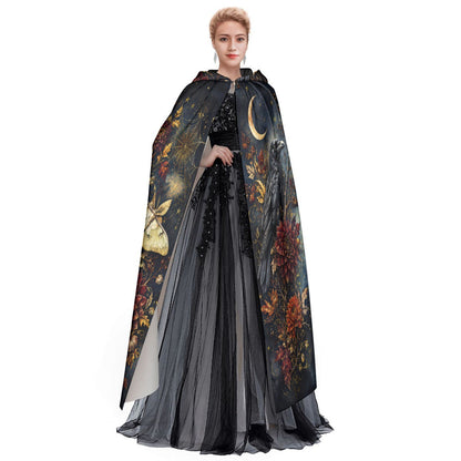 Model wearing hooded cloak cape with moth graphic and flowing floral pattern