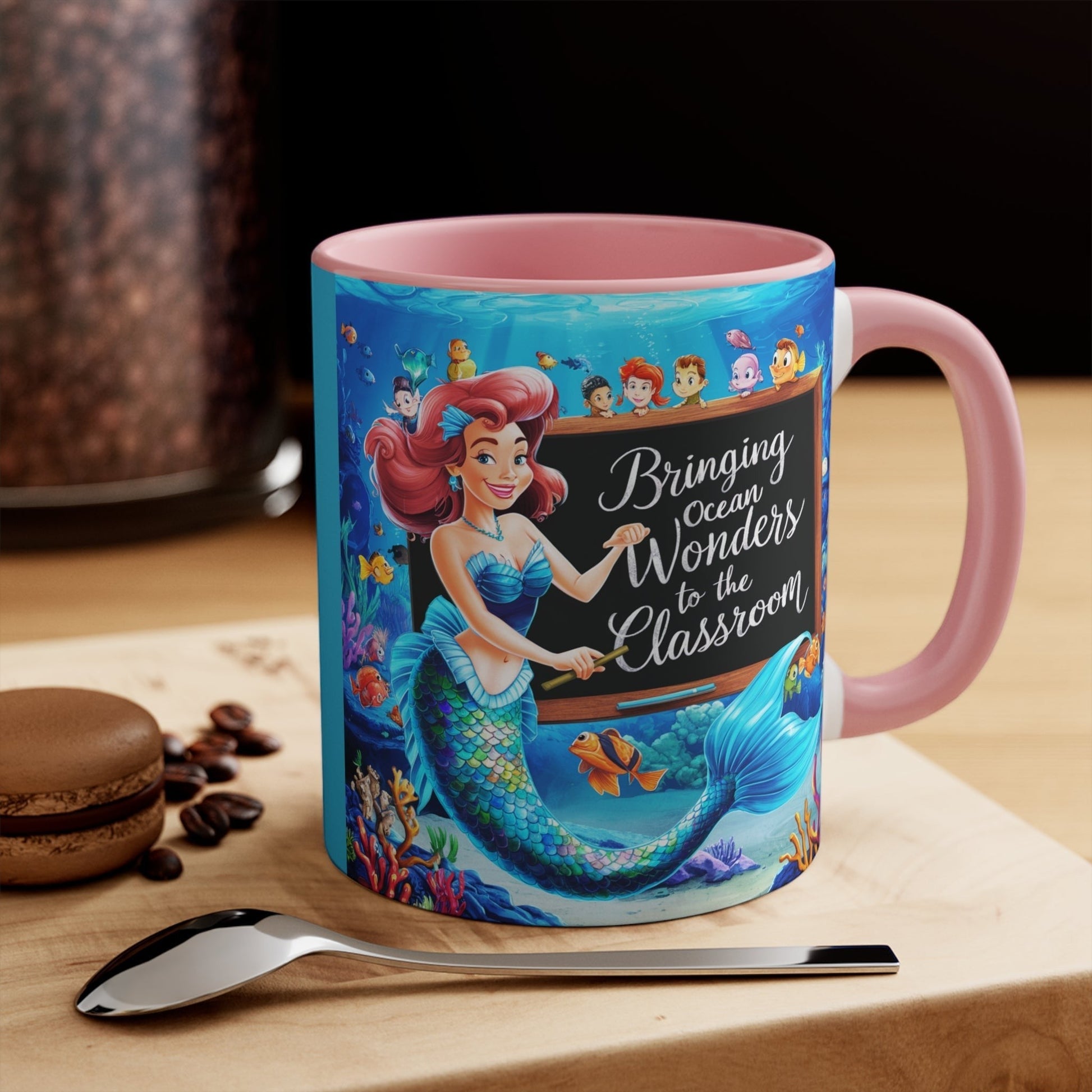 Pink ceramic accent mug with mermaid and ocean friends graphic, handle-on-right view.
