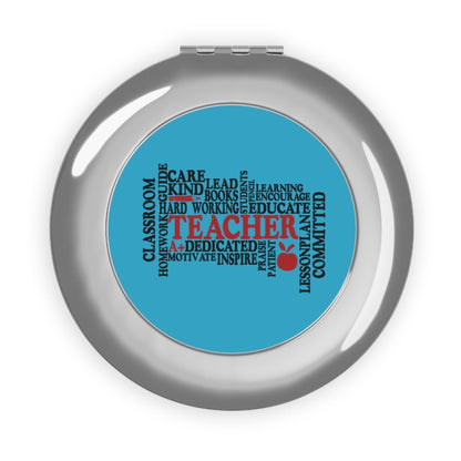 Compact travel mirror with silver glossy round case and blue word-collage center