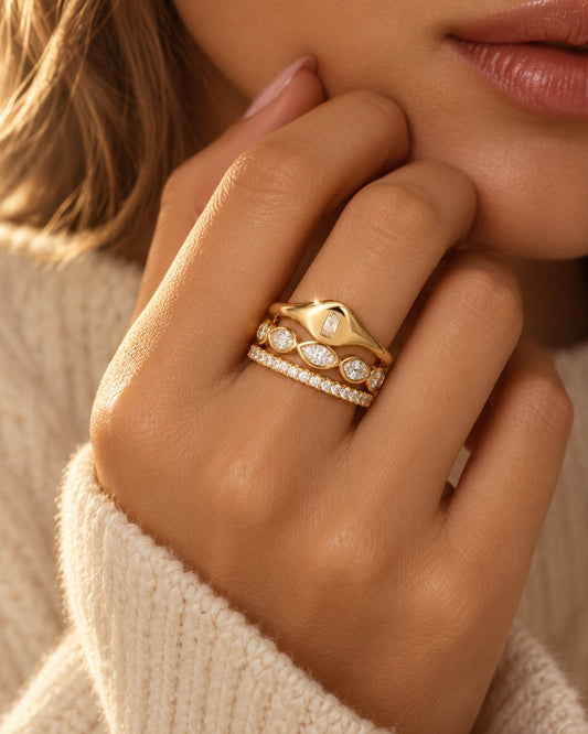 Gold ring with stacked marquise-style and round clear stones on the band