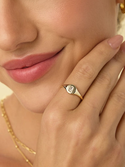 Gold-tone signet ring with small square baguette crystal at the center