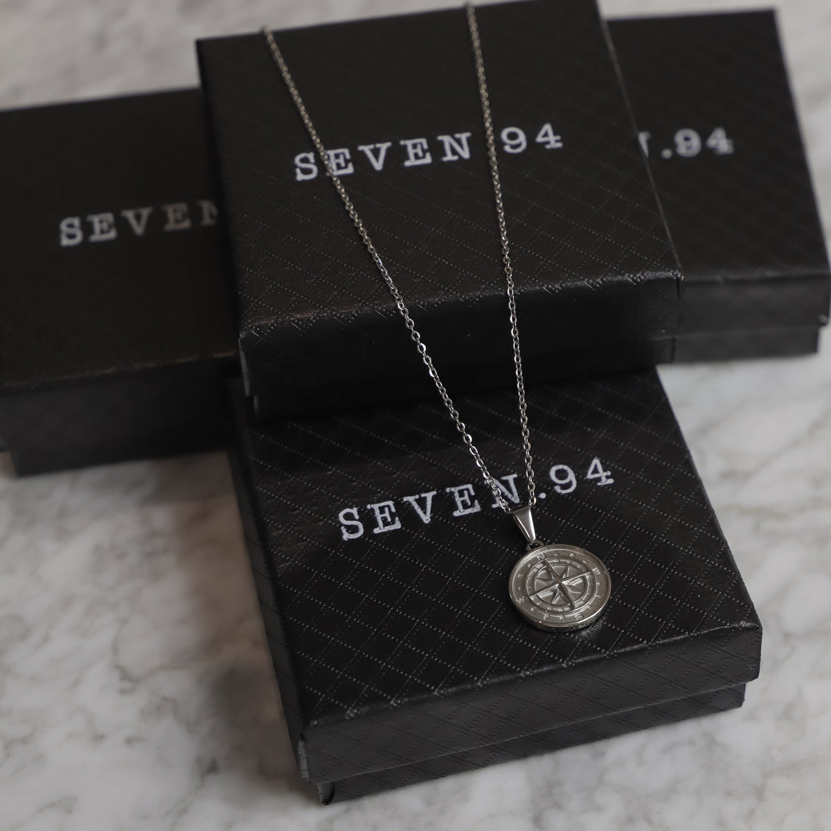 Silver compass pendant necklace with round compass medallion on a chain