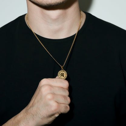 Gold Spartan warrior pendant necklace featuring round coin pendant, close-up on collar.