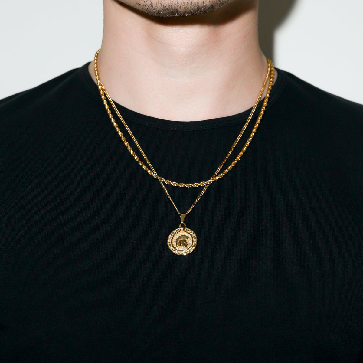 Gold Spartan warrior pendant necklace layered look with round medal pendant at center.