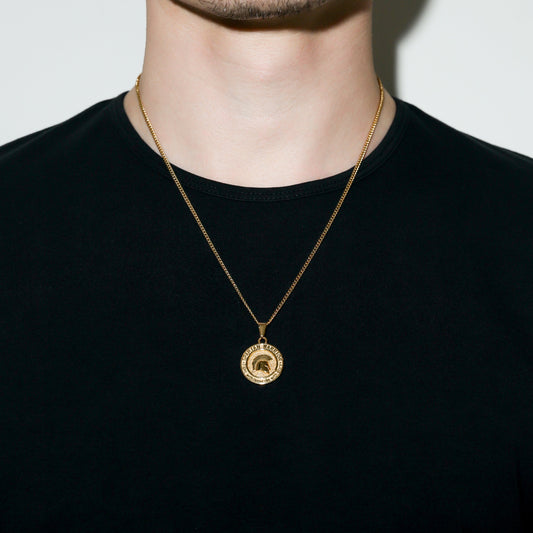 Gold Spartan warrior pendant necklace on neck with round medal-style charm.