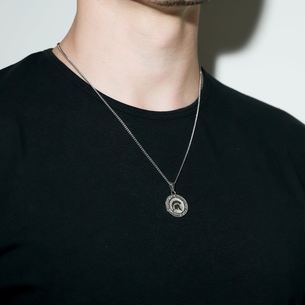 Silver Spartan warrior pendant necklace with small round emblem pendant centered.