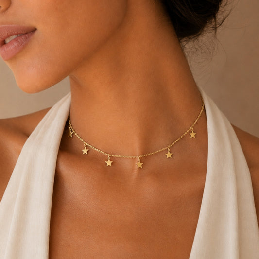 Gold star charm choker necklace on neck with five star charms