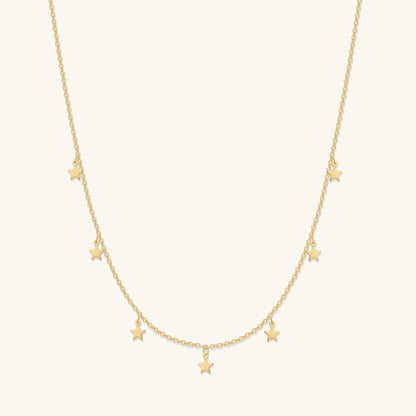 Gold crescent moon and star necklace with small star charms along the chain