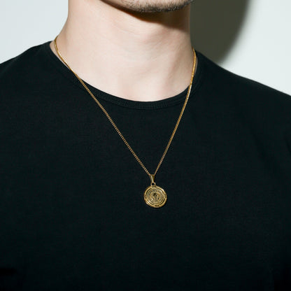 Gold Saint Benedict medal necklace with round medal pendant centered on chest
